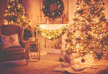 Image showing Christmas interior concept. With fireplace, armchair, pine tree, wrapped gifts, lights