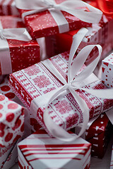 Image showing Christmas concept. Close up on festive paper wrapped gifts with ribbon