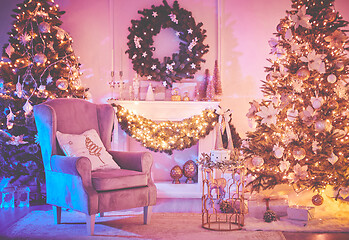 Image showing Christmas interior concept. With fireplace, armchair, pine tree, wrapped gifts, lights