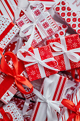 Image showing Various pattern and size Christmas boxes placed on white background. Wrapped in festive paper