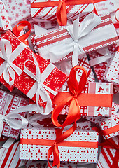 Image showing A pile various size wrapped in festive paper boxed gifts placed on stack. Christmas concept