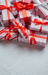 Image showing A pile various size wrapped in festive paper boxed gifts placed on stack. Christmas concept