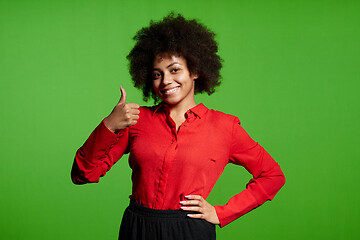 Image showing Smiling young African-American girl looking at camera gesturing thumb up