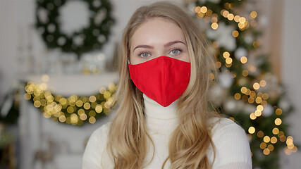 Image showing Portrait of a beautiful woman. Woman wears the protective mask from the virus. Pandemic Christmas