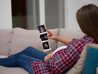 Image showing pregnant woman looking baby\'s ultrasound