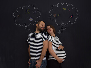 Image showing pregnant couple posing against black chalk drawing board