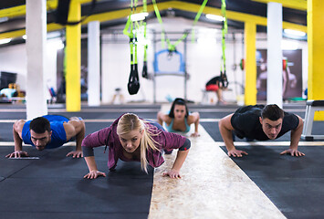 Image showing young healthy people doing pushups