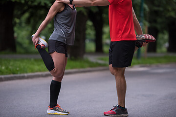 Image showing runners team warming up and stretching before morning training