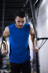 Image showing man working out pull ups with gymnastic rings