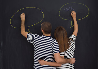 Image showing pregnant couple writing on a black chalkboard