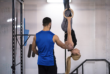 Image showing woman working out with personal trainer on gymnastic rings