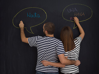 Image showing pregnant couple writing on a black chalkboard