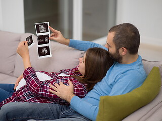 Image showing pregnant couple looking baby\'s ultrasound