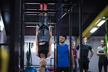 Image showing woman working out with personal trainer on gymnastic rings