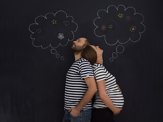 Image showing pregnant couple posing against black chalk drawing board