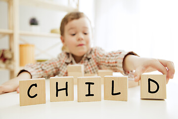 Image showing Wooden cubes with word CHILD in hands of little boy