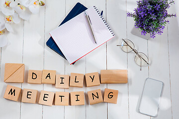 Image showing DAILY MEETING. Message at wooden cubes on a desk background.