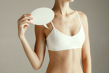 Image showing Young adult woman holding empty paper card for sign or symbol.