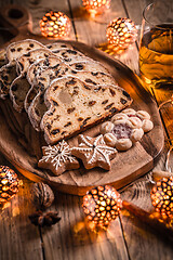 Image showing Christmas Stollen with apple mulled wine. Traditional Sweet Fruit Loaf with icing sugar.  