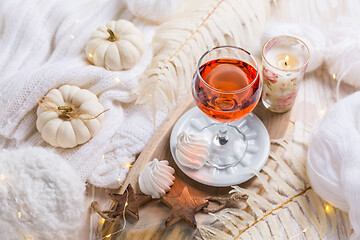 Image showing Cosy still life for winter and autumn with glass of pink wine, pumpkin and cookie