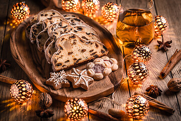 Image showing Christmas Stollen with apple mulled wine. Traditional Sweet Fruit Loaf with icing sugar.  