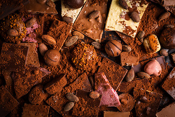 Image showing Variation of chocolate and candy with cocoa and cocoa beans as background