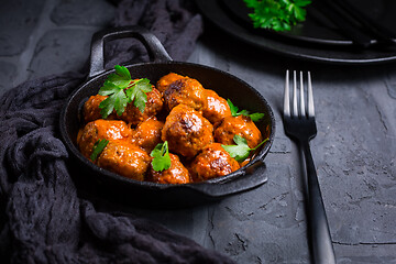 Image showing Meatballs with tomato sauce in black pan