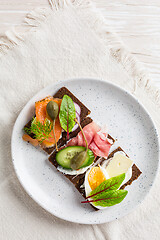 Image showing Variation of healthy open sandwiches on Pumpernickel bread with vegetables, salmon, ham, herbs and soft cheese