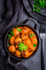 Image showing Meatballs with tomato sauce in black pan