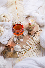 Image showing Cosy still life for winter and autumn with glass of pink wine, pumpkin and cookie