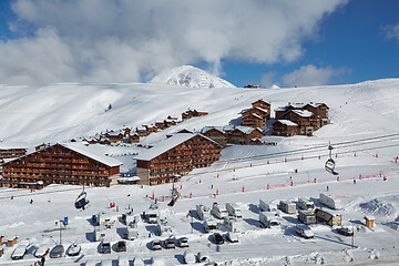 Image showing Snowy mountain skiing village, falling snow