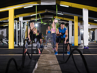 Image showing sports couple doing battle ropes cross fitness exercise