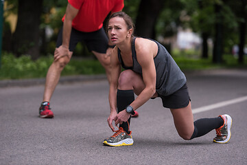 Image showing sporty woman tying running shoes laces