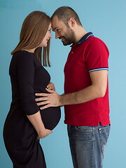 Image showing pregnant couple  isolated over blue background