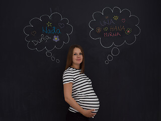 Image showing pregnant woman thinking in front of black chalkboard