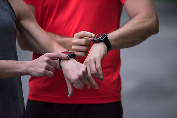 Image showing sporty couple using smart watches