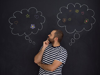 Image showing young future father thinking in front of black chalkboard