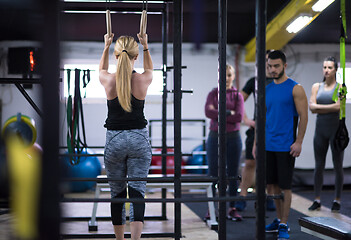 Image showing woman working out with personal trainer on gymnastic rings