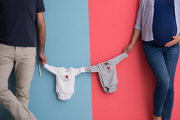 Image showing young couple holding baby bodysuits