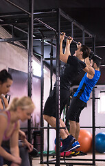 Image showing young athletes doing pull ups on the horizontal bar