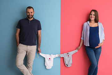 Image showing young couple holding baby bodysuits