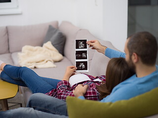 Image showing pregnant couple looking baby\'s ultrasound