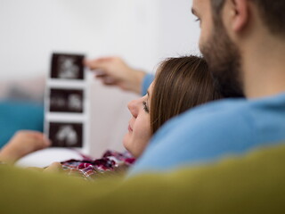 Image showing pregnant couple looking baby\'s ultrasound