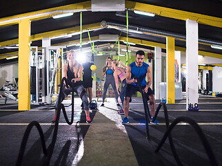 Image showing sports couple doing battle ropes cross fitness exercise