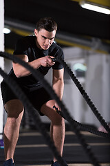 Image showing athlete man doing battle ropes cross fitness exercise