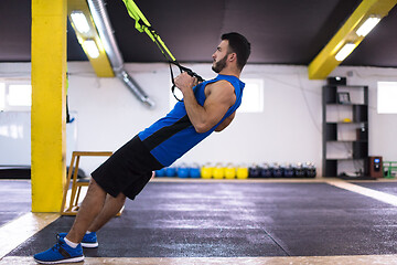 Image showing man working out pull ups with gymnastic rings