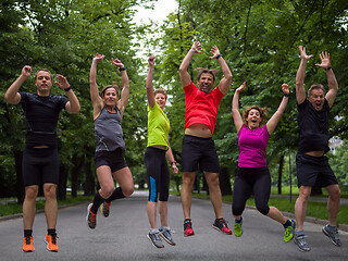 Image showing runners team jumping in the air during  morning training