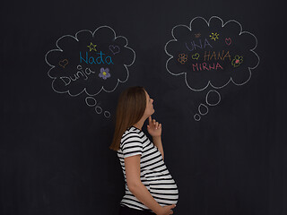 Image showing pregnant woman thinking in front of black chalkboard