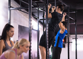 Image showing young athletes doing pull ups on the horizontal bar