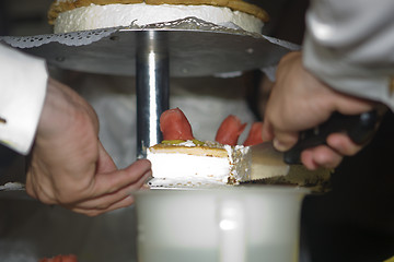 Image showing Groom cutting wedding cake